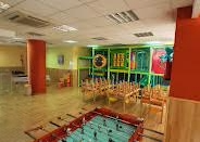 Sala amb futbolí en primer pla i el parc de boles al fons